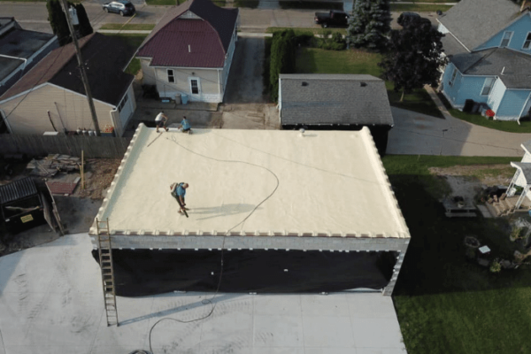 The application of spray foam insulation to the roof of a commercial building.
